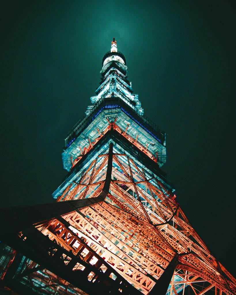 Stunning low-angle capture of Tokyo Tower glowing under night sky, showcasing its architectural brilliance.